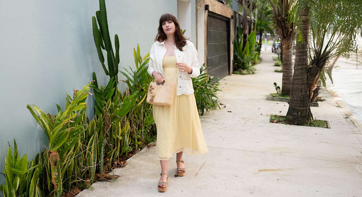 Frau im sommerlichen Outfit mit gelbem Kleid und Keilsandaletten