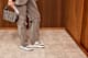 Frau in grauen Cargopants, trägt Fila-Handtasche und funktionale Sneaker
