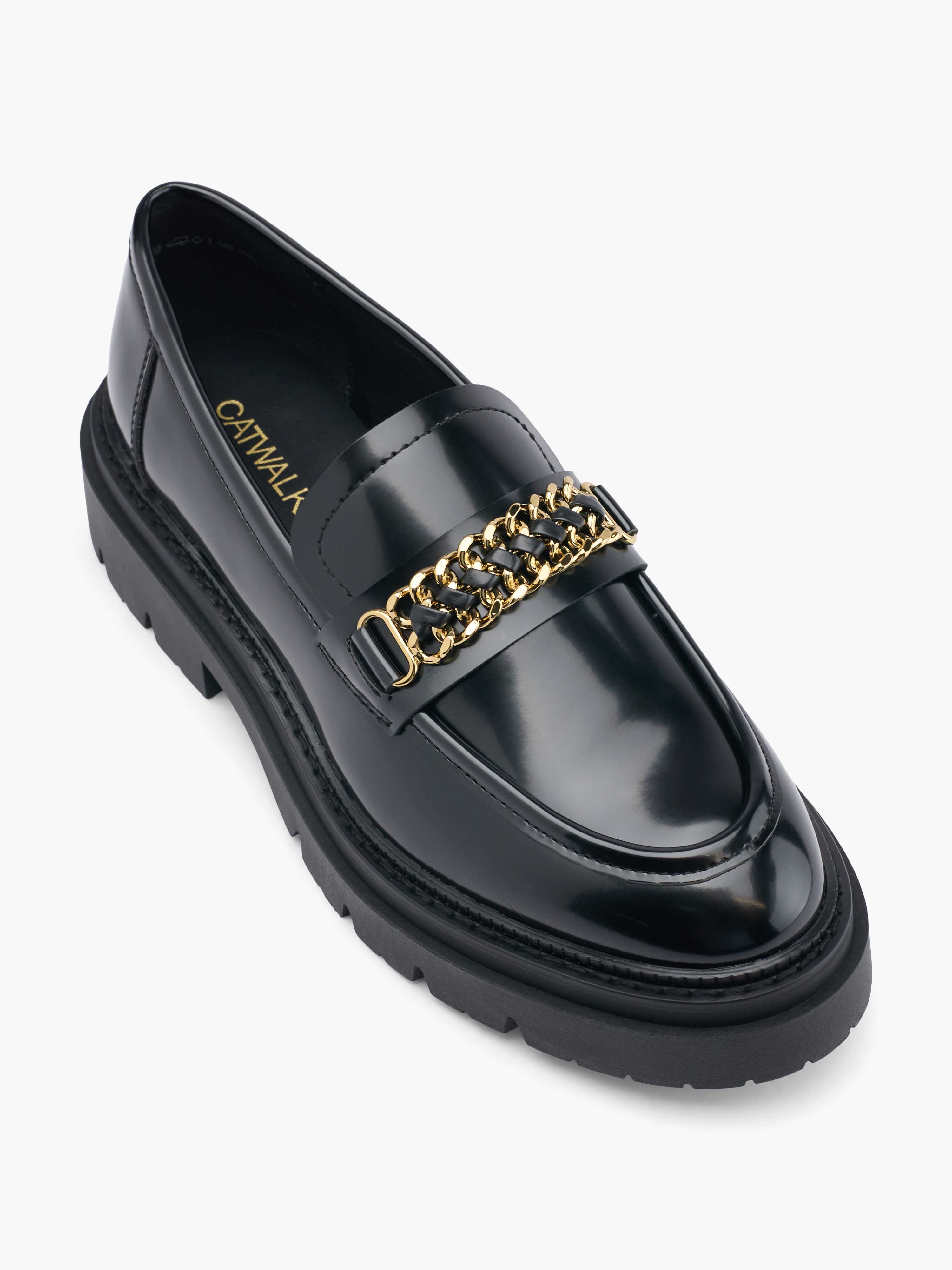 Top-Down-Ansicht eines glänzend schwarzen Loafers mit Ketten-Applikationen, vor weißem Hintergrund