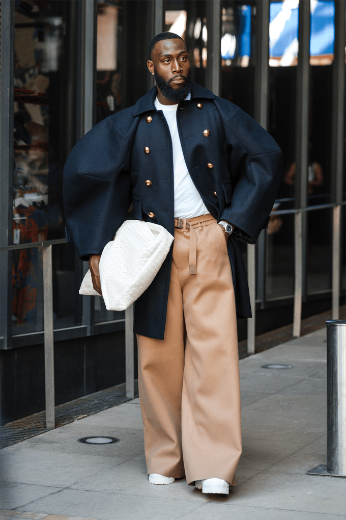 Mann mit modern-blauem Zweireiher und weit geschnittener Hose in Hellbraun