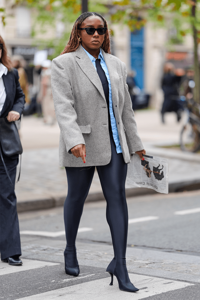 Frau trägt professionellen grauen Blazer in Kombination mit shiny Yogapants und High Heels