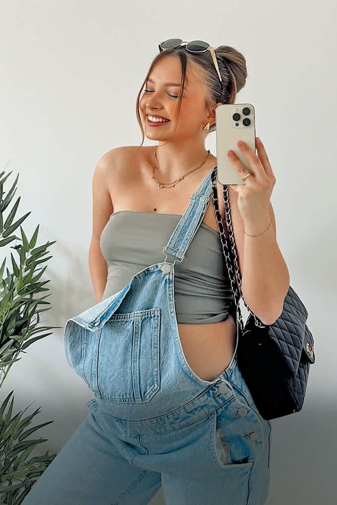 Influencerin Alina Mour in Latzhose beim Selfie vor einem Spiegel