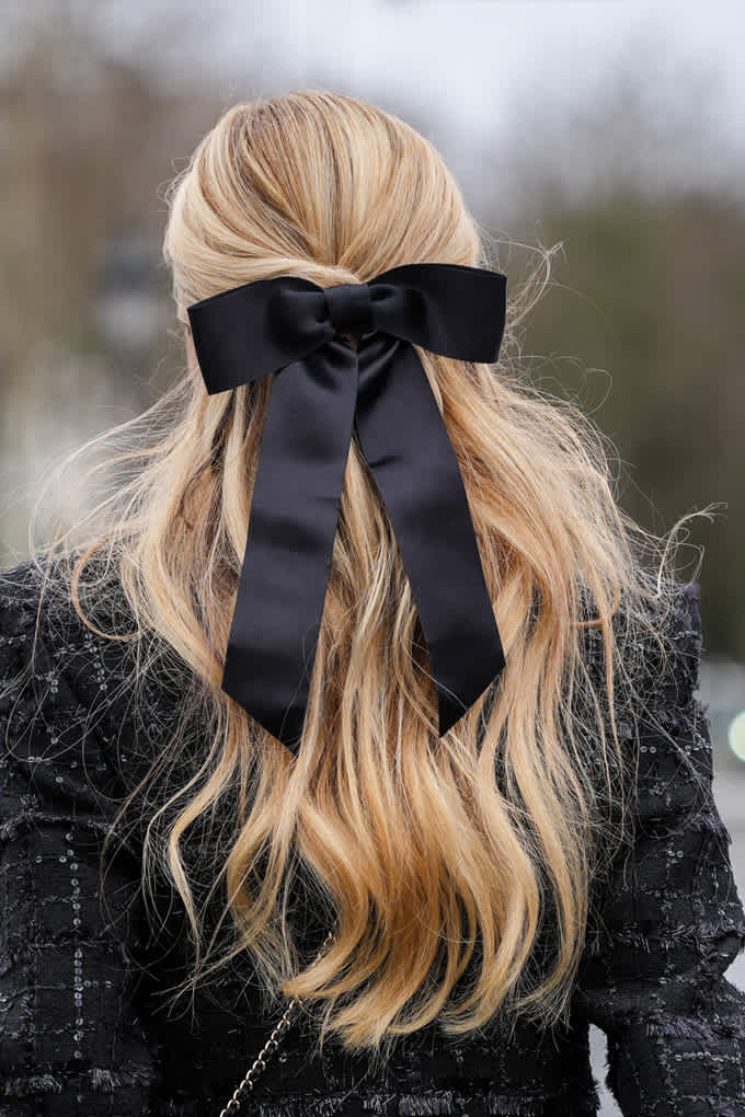 Blonde Frau mit schwarzer Schleife in den Haaren als Accessoire