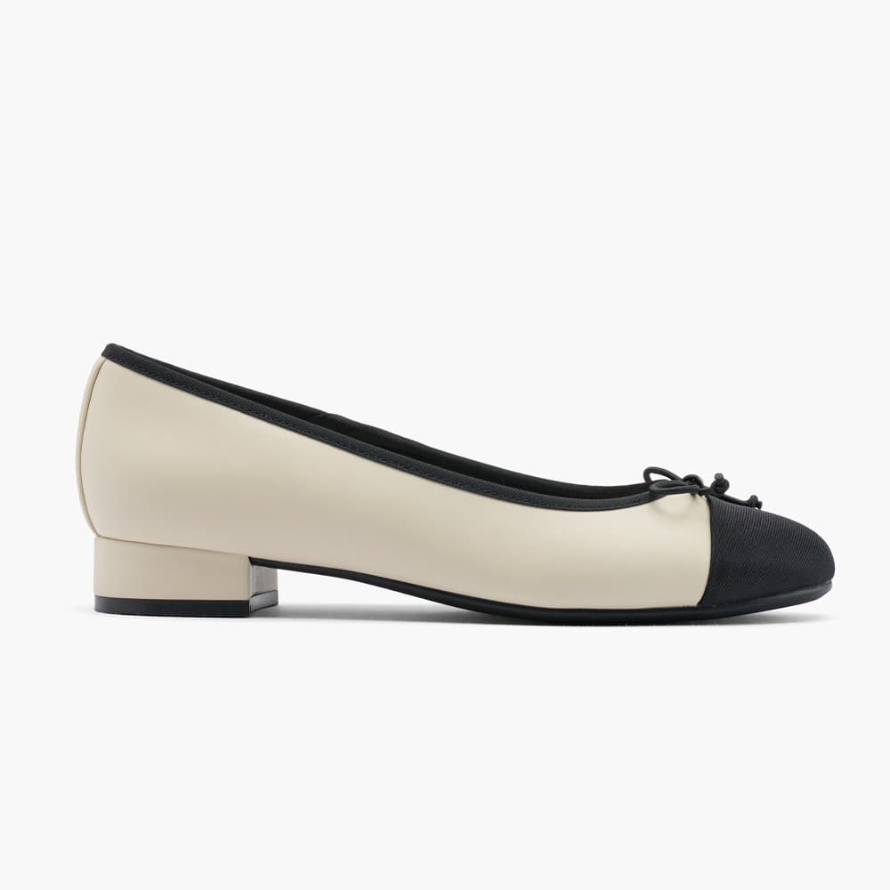 Weißer Pump mit schwarzer Schuhspitze