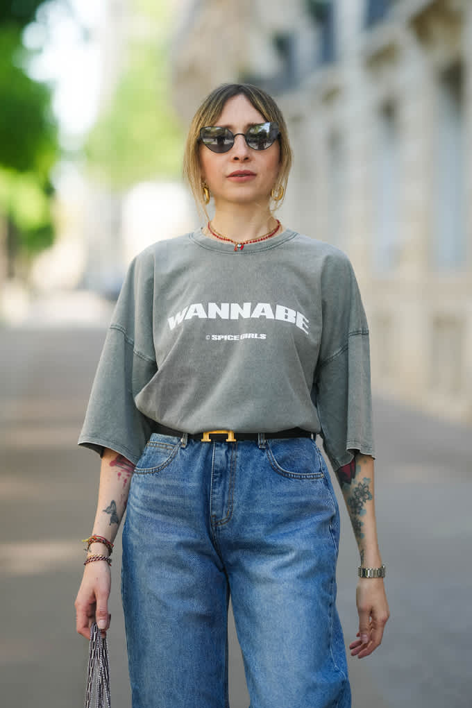 Blonde Frau mit grauem T-Shirt und Jeanshose, stehend auf Straße