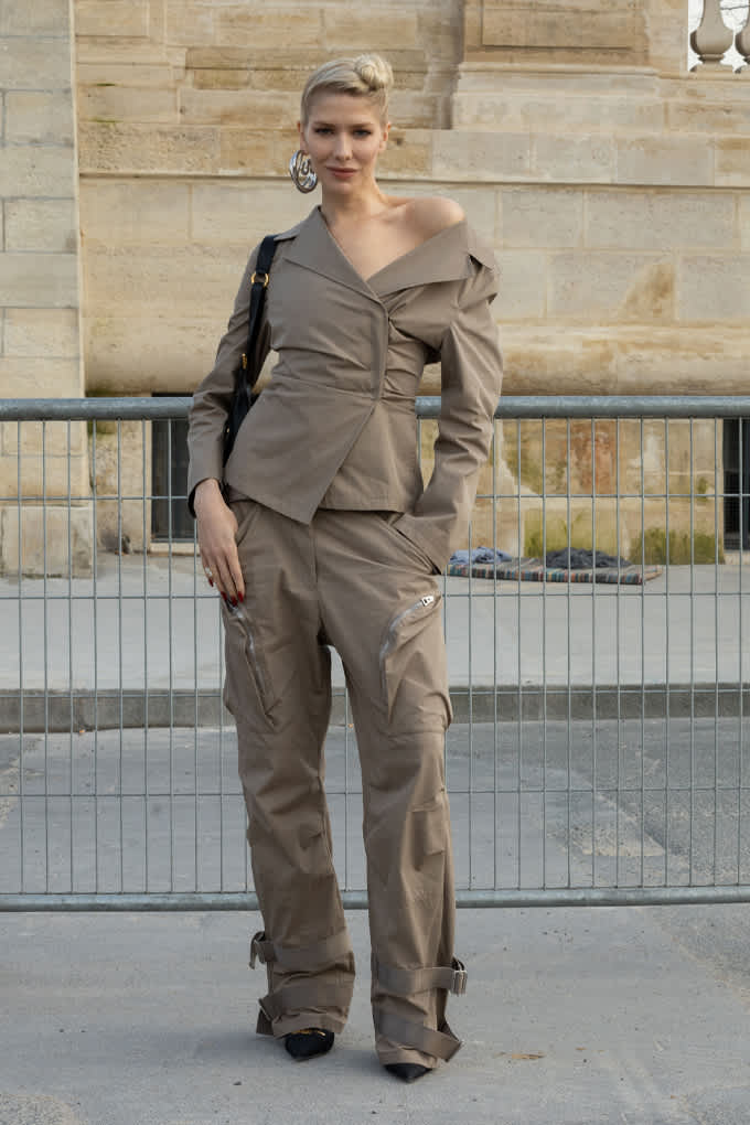 Frau posiert in grauer Off-Shoulder-Jacke, kombiniert Utility Cargo-Shorts