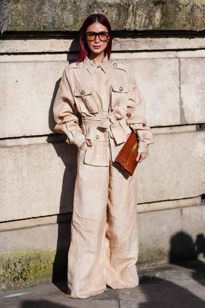 Frau in sandfarbenem Utility-Jumpsuit mit Taillengürtel