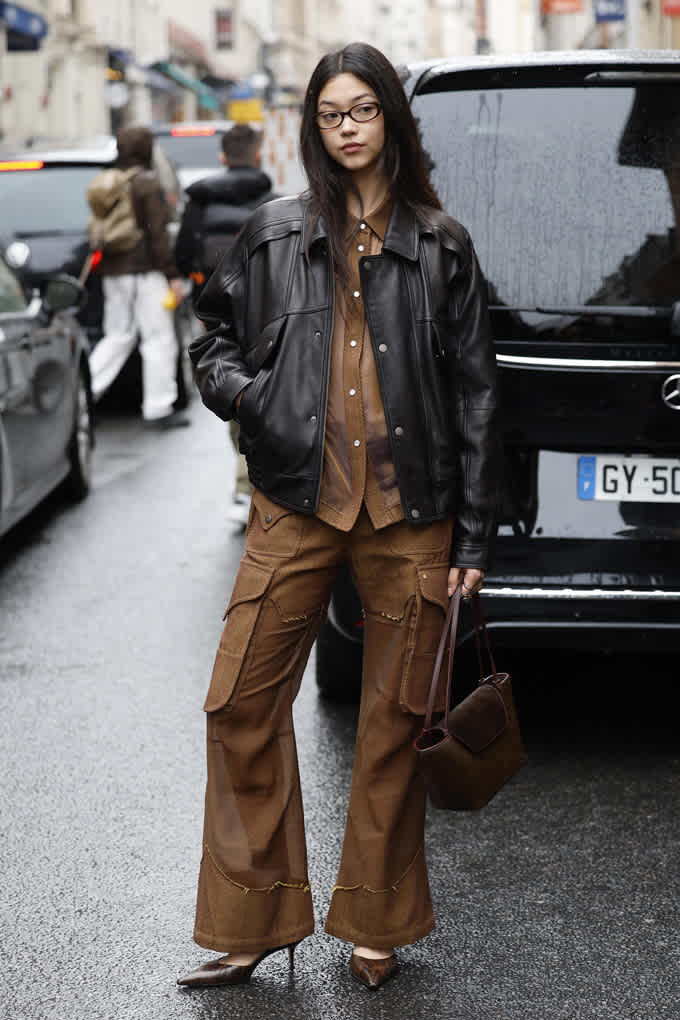 Frau in braunem Ton-in-Ton Utility-Look, kombiniert mit schwarzer Jacke