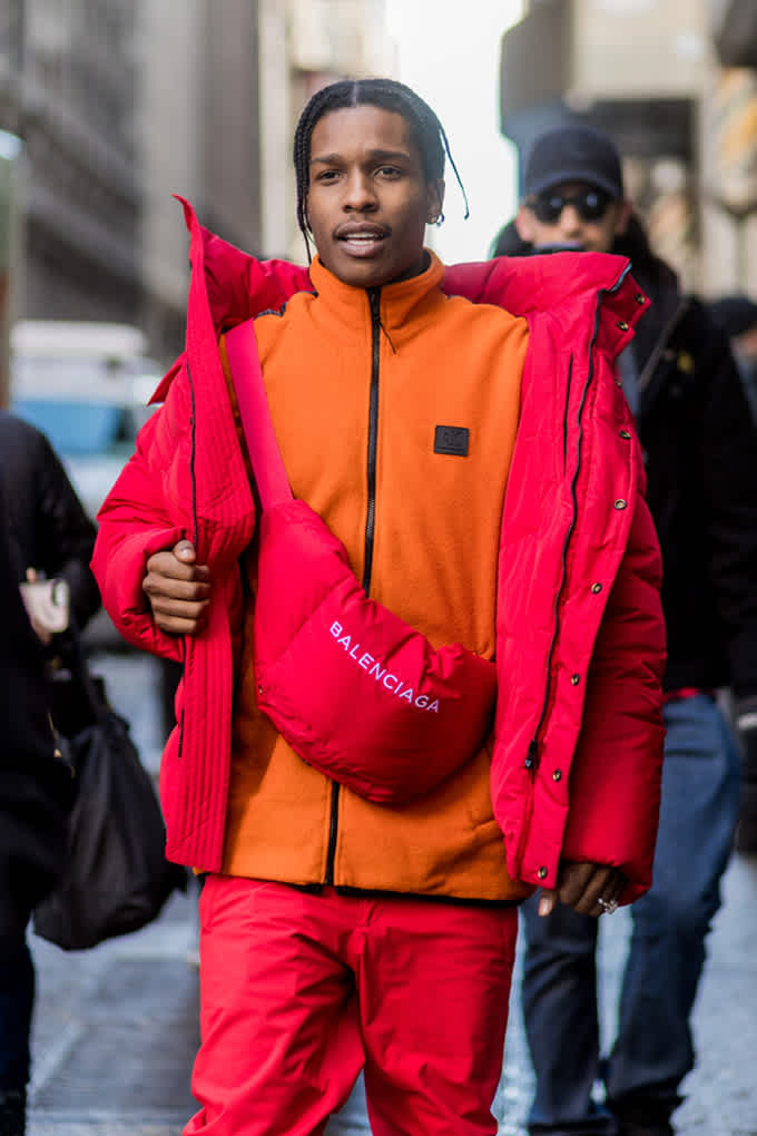 A$AP Rocky trägt knallbuntes Outfit mit roter Winterjacke und orangefarbener Sportjacke
