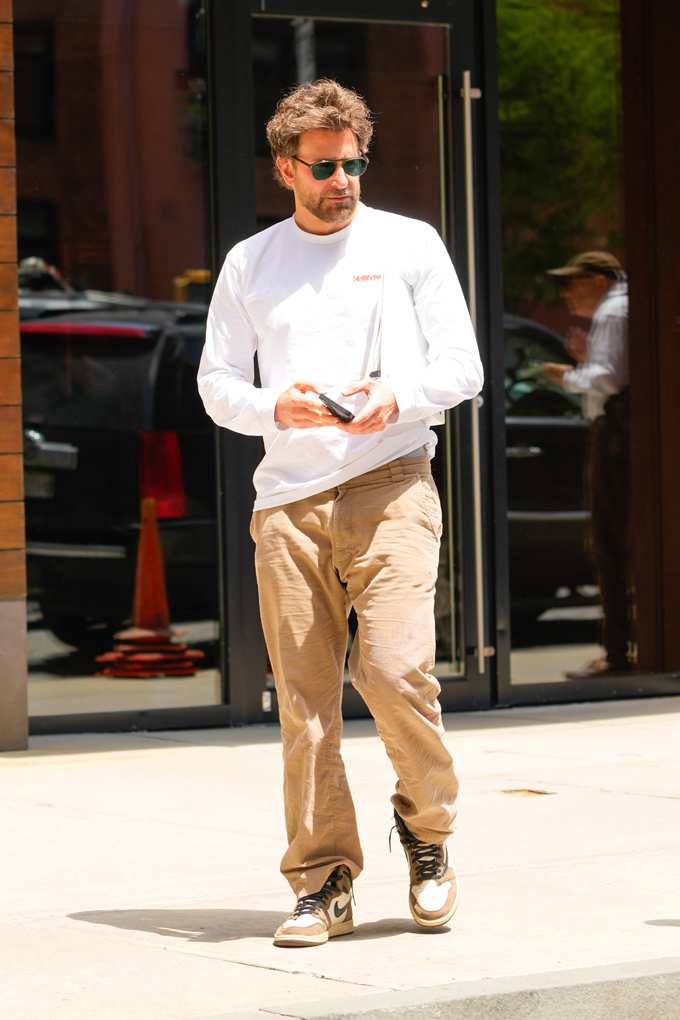 Ein Mann trägt ein weißes Longsleeve, eine beige Hose und Nike-Sneaker
