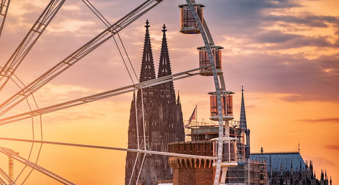 Riesenrad mit Kölner Dom im Hintergrund, bei Sonnenuntergang