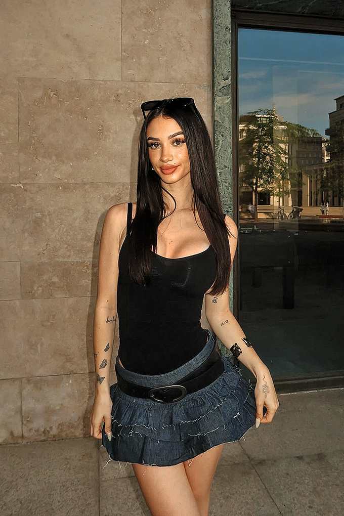 Influencerin Rossella mit schwarzem Top und Jeans-Rock 