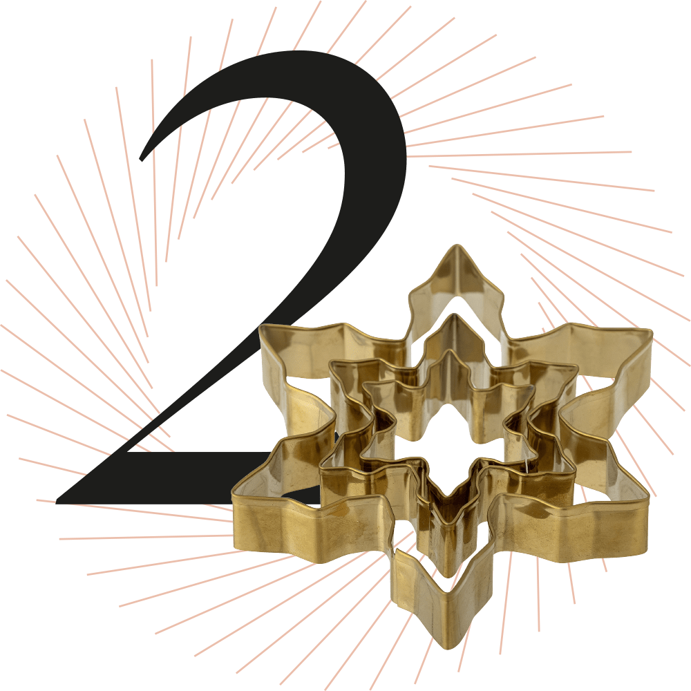 Ausstechform in Schneeflocken-Form, schwarze Ziffer 2 im Hintergrund