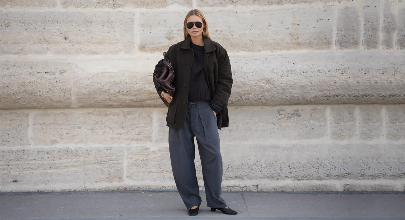 Frau in schwarzem Shacket mit Wide-Leg-Jeans und passenden Mary Janes