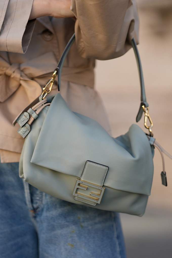 Frau trägt salbeigrüne Baguette Bag am Arm