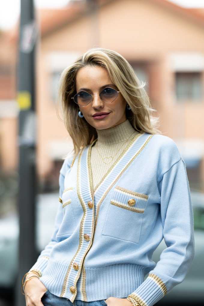 Blonde Frau mit Sonnenbrille und pastellfarbenem Pullover