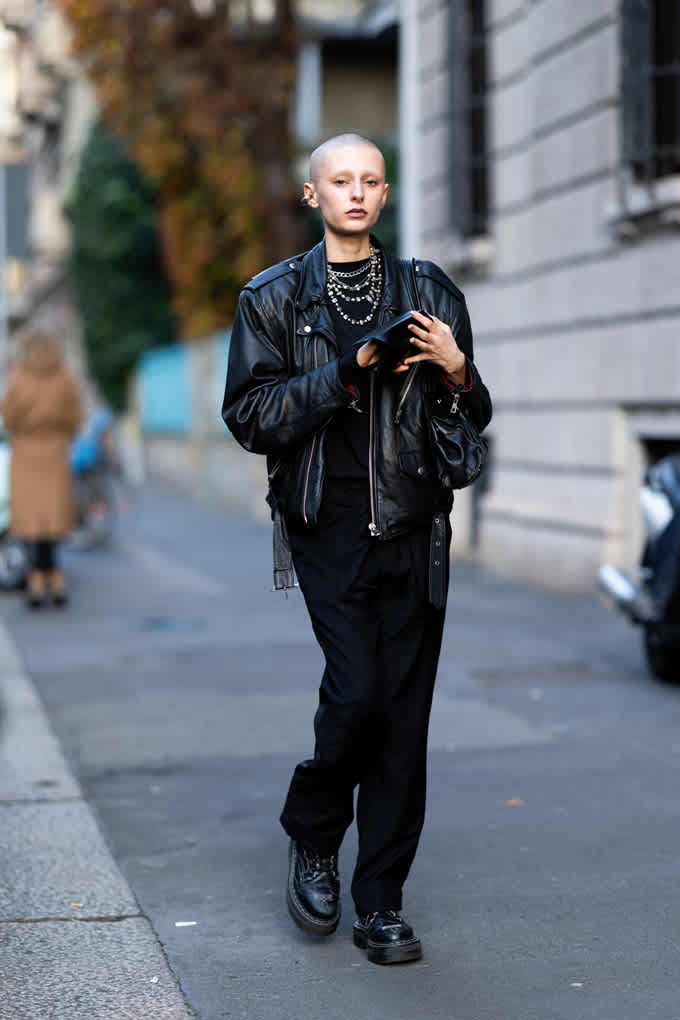 Frau trägt ein schwarzes Leder-Outfit, bestehend aus Leder-Jacke, passender Hose und Chunky Boots