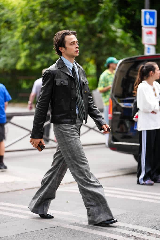 Mann trägt Kombination aus Lederjacke und Anzug-Shirt mit Krawatte, kombiniert mit Wide Leg-Jeans