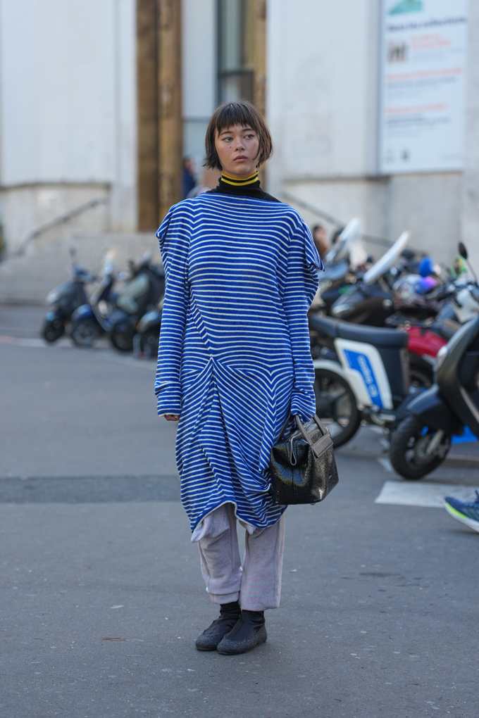 Frau posiert in übergroßem Streifenkleid