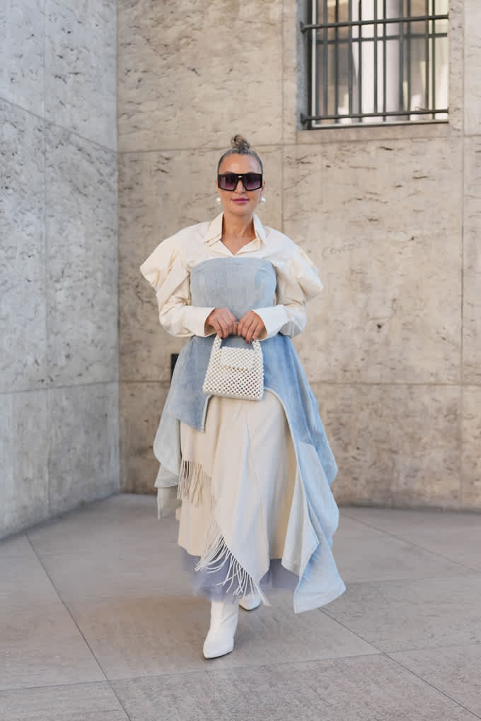 Frau mit Sonnenbrille, trägt weißes Hemd, darüber hellblaue fließende Layer mit passenden Boots