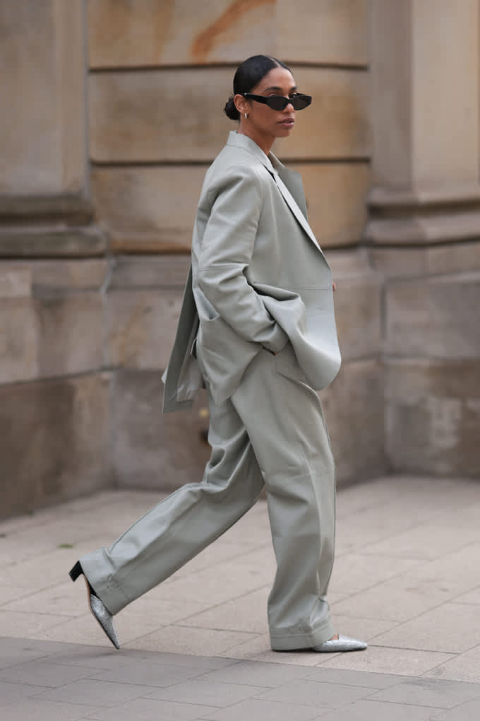 Frau mit schwarzer Sonnenbrille trägt grauenOversize-Anzugkombination