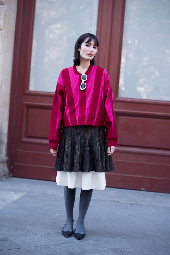 Frau trägt rot-gestreiften Statement-Pullover in Kombination mit zwei Röcken