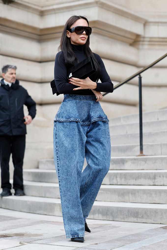 Junge Frau mit schwarzem Slim-Fit-Rolli trägt High Waist-Barrel Jeans
