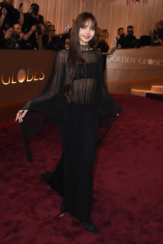 Frau in schwarz-halbtransparenten Kleid auf rotem Teppich