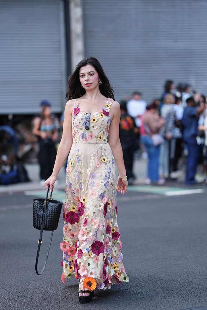 Schwarzhaarige Frau trägt transparentes Nude-Kleid mit 3D-Blüten-Applikationen