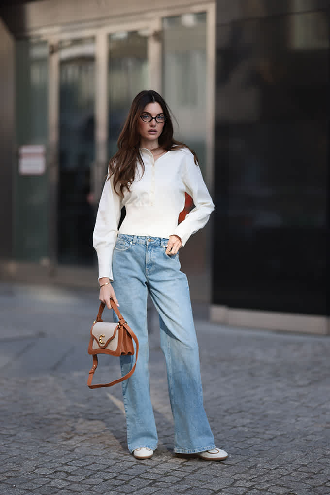 Frau trägt weiße Bluse mit heller Jeanshose und spitzen Heels