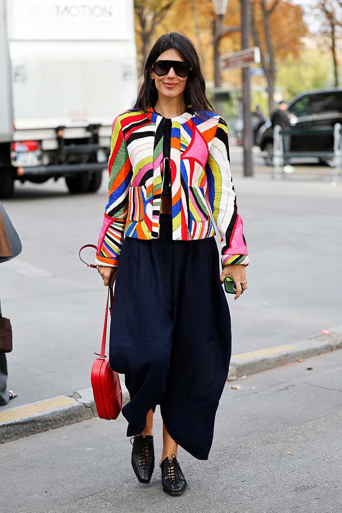 Frau in bunt-gestreifter Jacke mit schwarzer Culotte und passenden Pumps