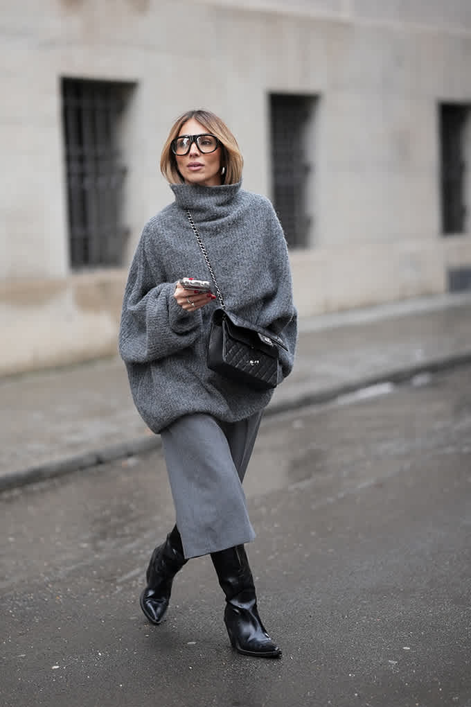 Frau trägt grauen Sweater mit passender Culotte und schwarzen Lederboots