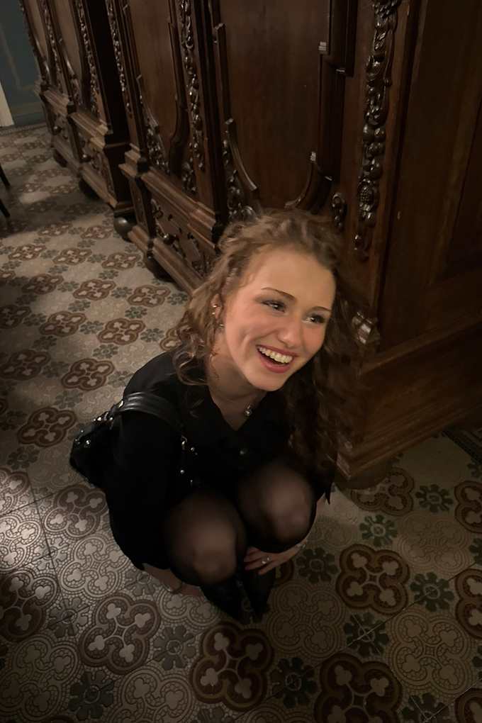 Influencerin Yana Clare hockt lächelnd auf Steinboden