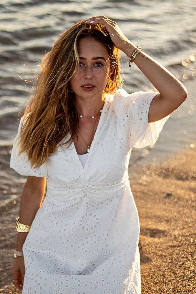 Influencerin Laura Sophie @laurasophie in weißem Hemdkleid, stehend am Strand 