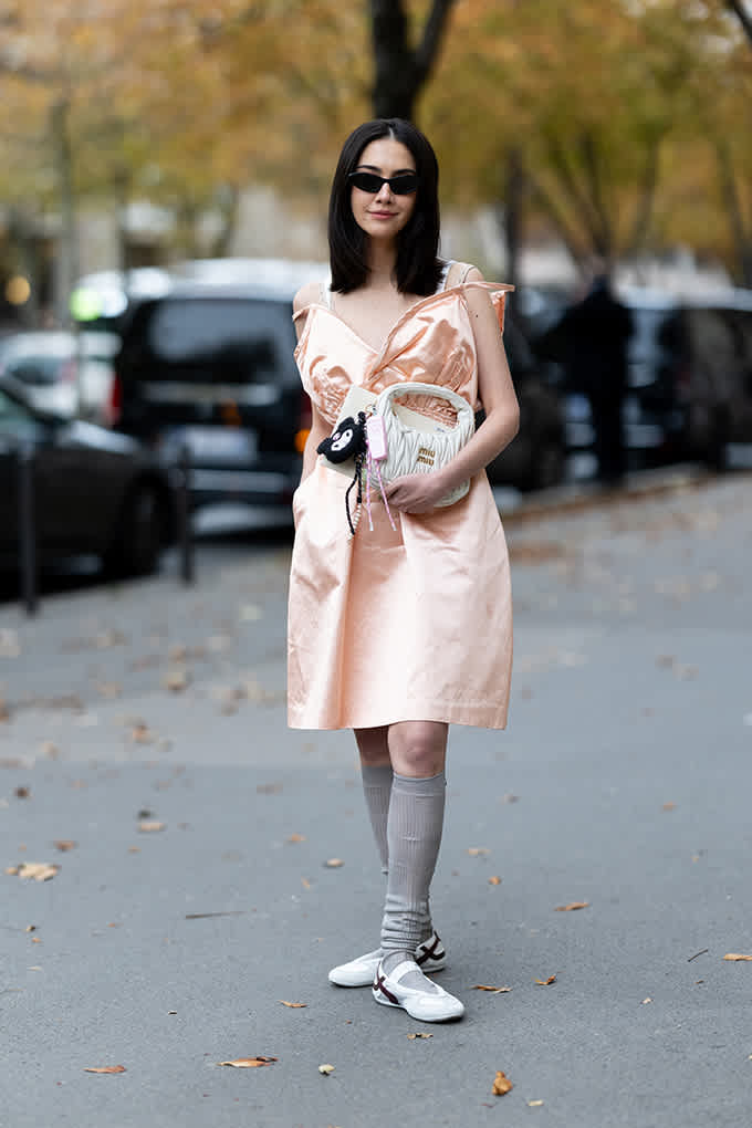 Frau trägt rosafarbenen Parker, kombiniert mit grauer Hose und Sneakerina-Schuhen