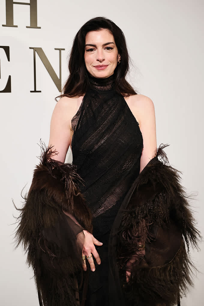 Schauspielerin Anne Hathaway in schwarzem Neckholderkleid mit passender Feder-Stola