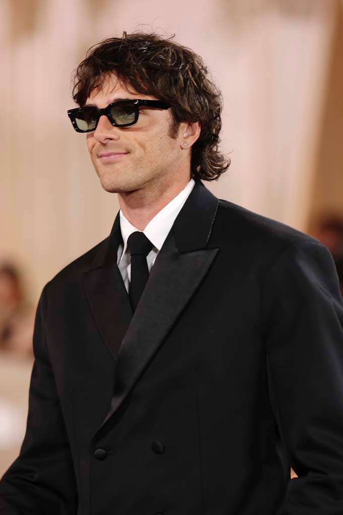 Mann in elegantem Outfit und Sonnenbrille mit Mullet