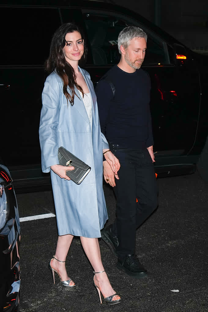 Anne Hathaway in männlicher Begleitung, trägt hellblauen Ledercoat zu silbernen Heels, kombiniert mit einer Clutch