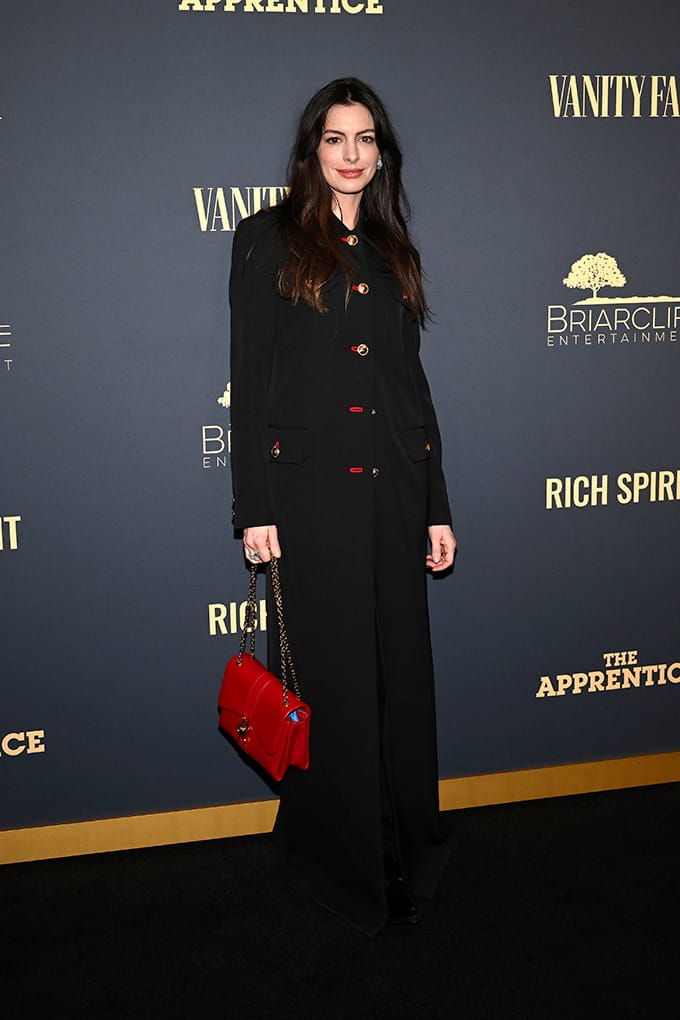 Anne Hathaway Style in schwarzem Coat-Dress mit roter Handtasche
