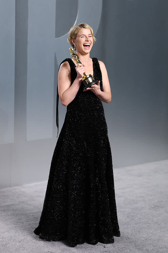 Schauspielerin Jesse Buckley in schwarzem Abendkleid und Oscar-Trophäe in der Hand