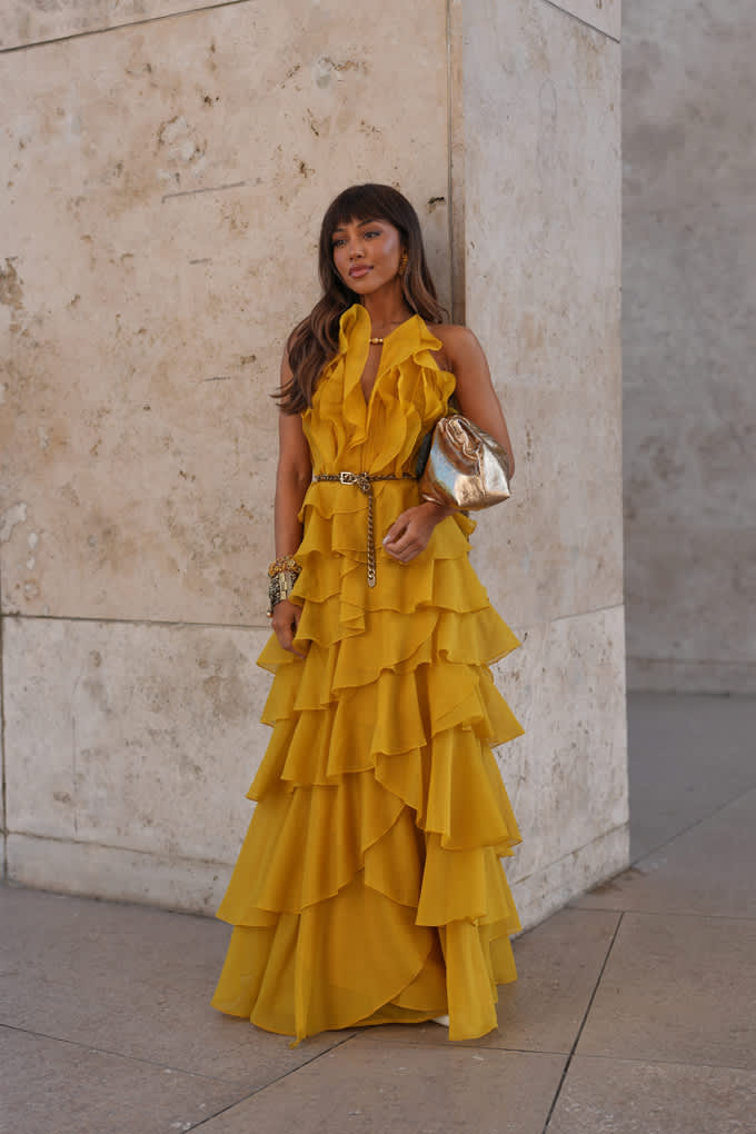 Frau mit goldenem Glitzer-Kleid mit silberner Umhängetasche