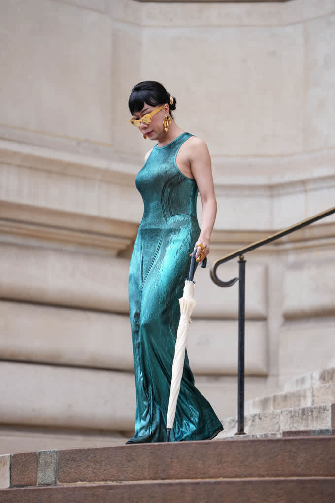 Frau trägt elegantes türkisfarbenes Metallic-Maxikleid für den Mirror-Look