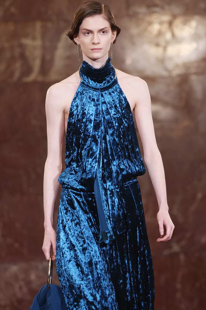 Frau in schulterfreiem Samt-Kleid in schillerndem Blau