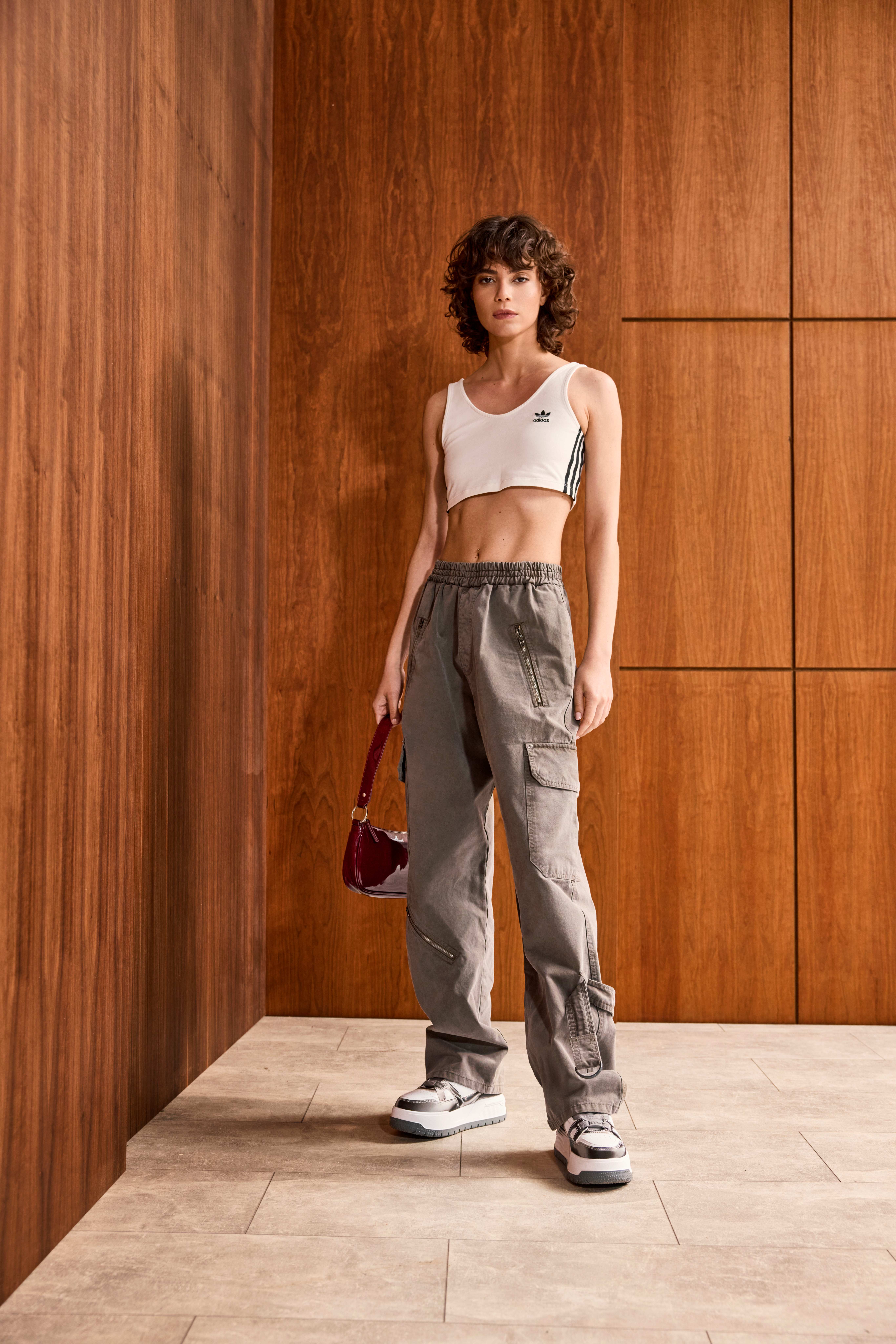 Frau in weißem Crop-Sporttop mit Cargo-Sweatpants, für den Y2K-Style
