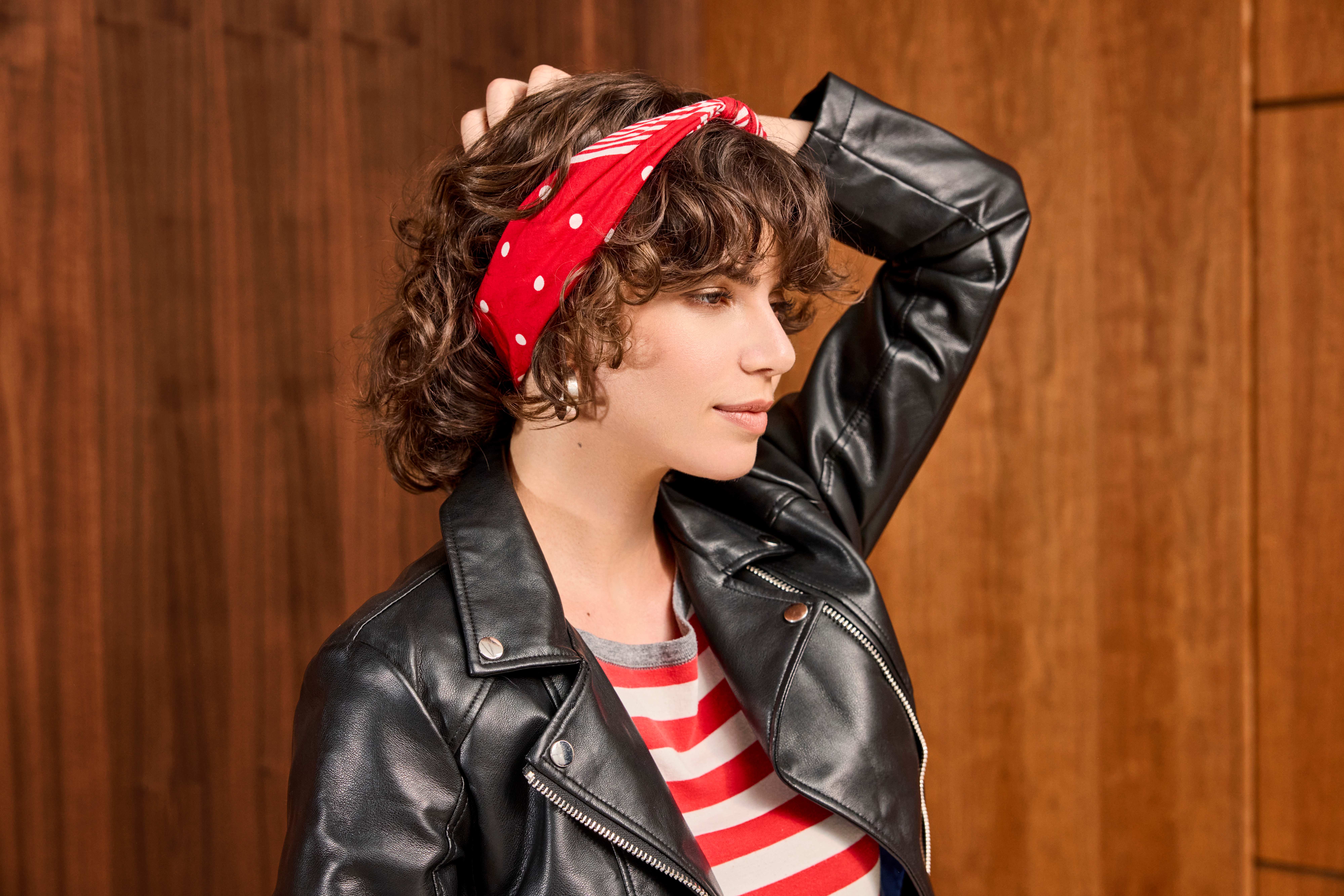 Frau trägt schwarze Lederjacke im Rockabilly-Style, kombiniert mit rot-weiß-gestreiftem Too und passendem Haartuch