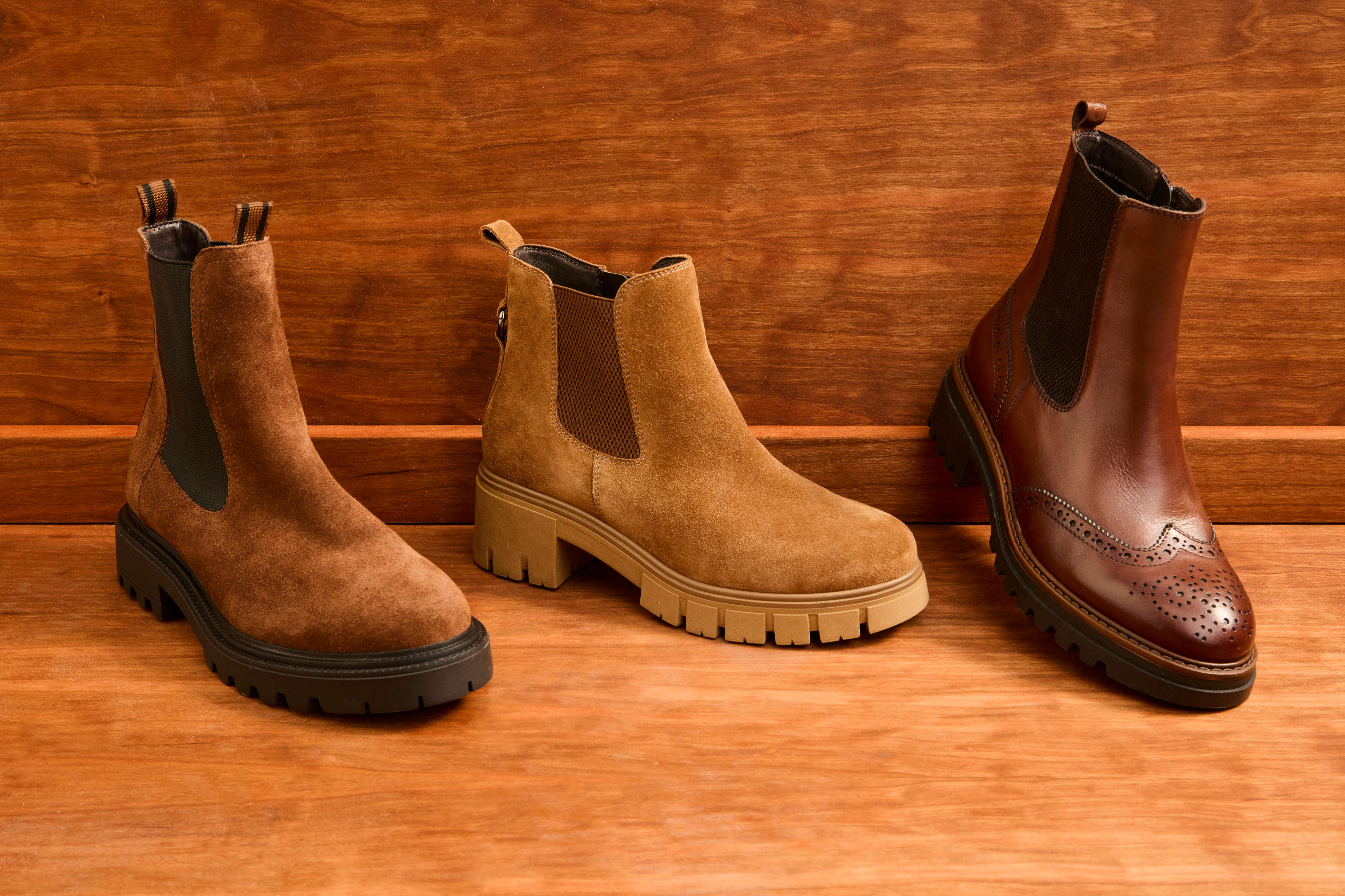 Drei Stiefel aus weichem Leder auf Holzboden