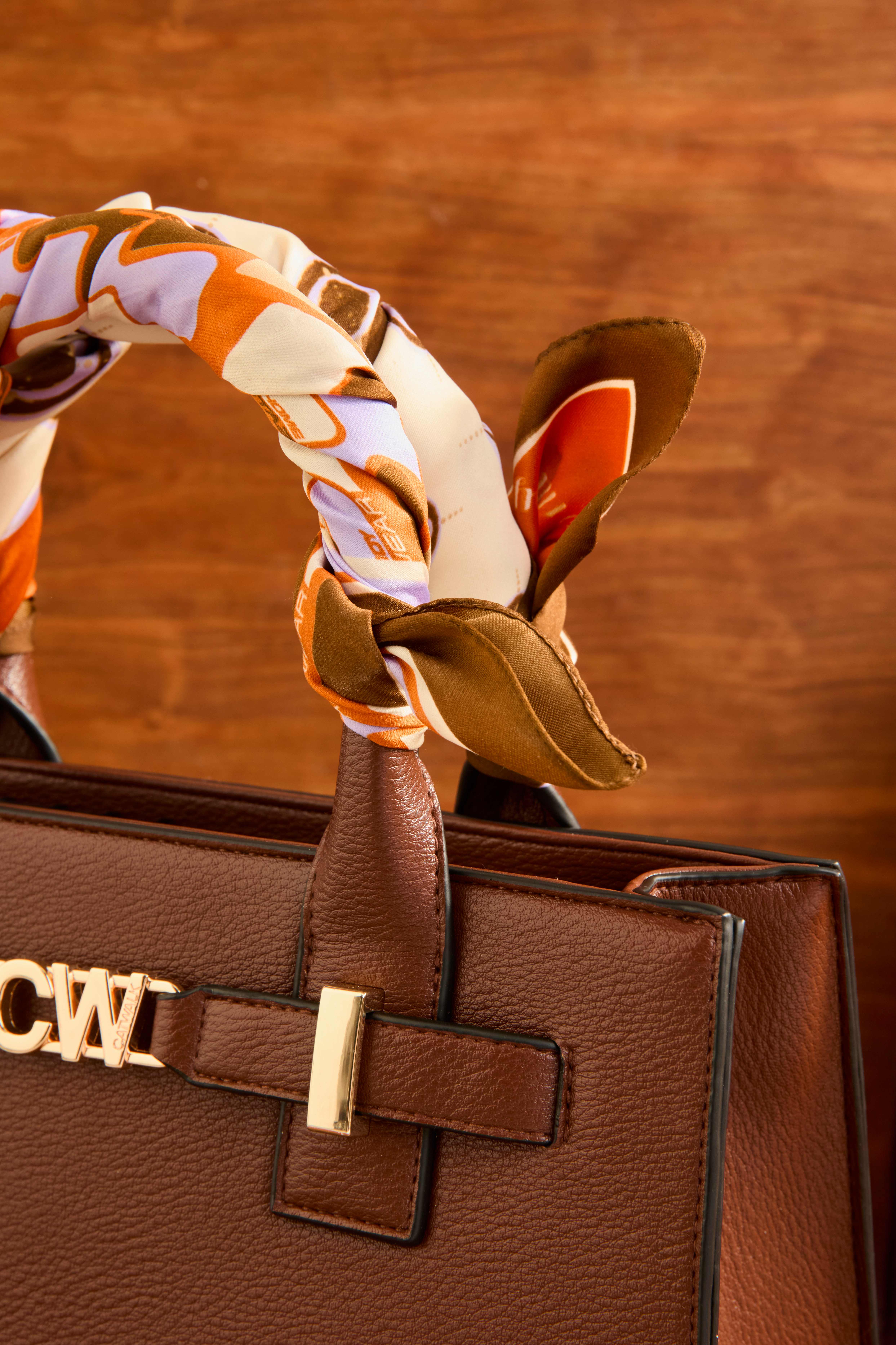 Buntes Foulard-Tuch, gewickelt um Griff einer Handtasche