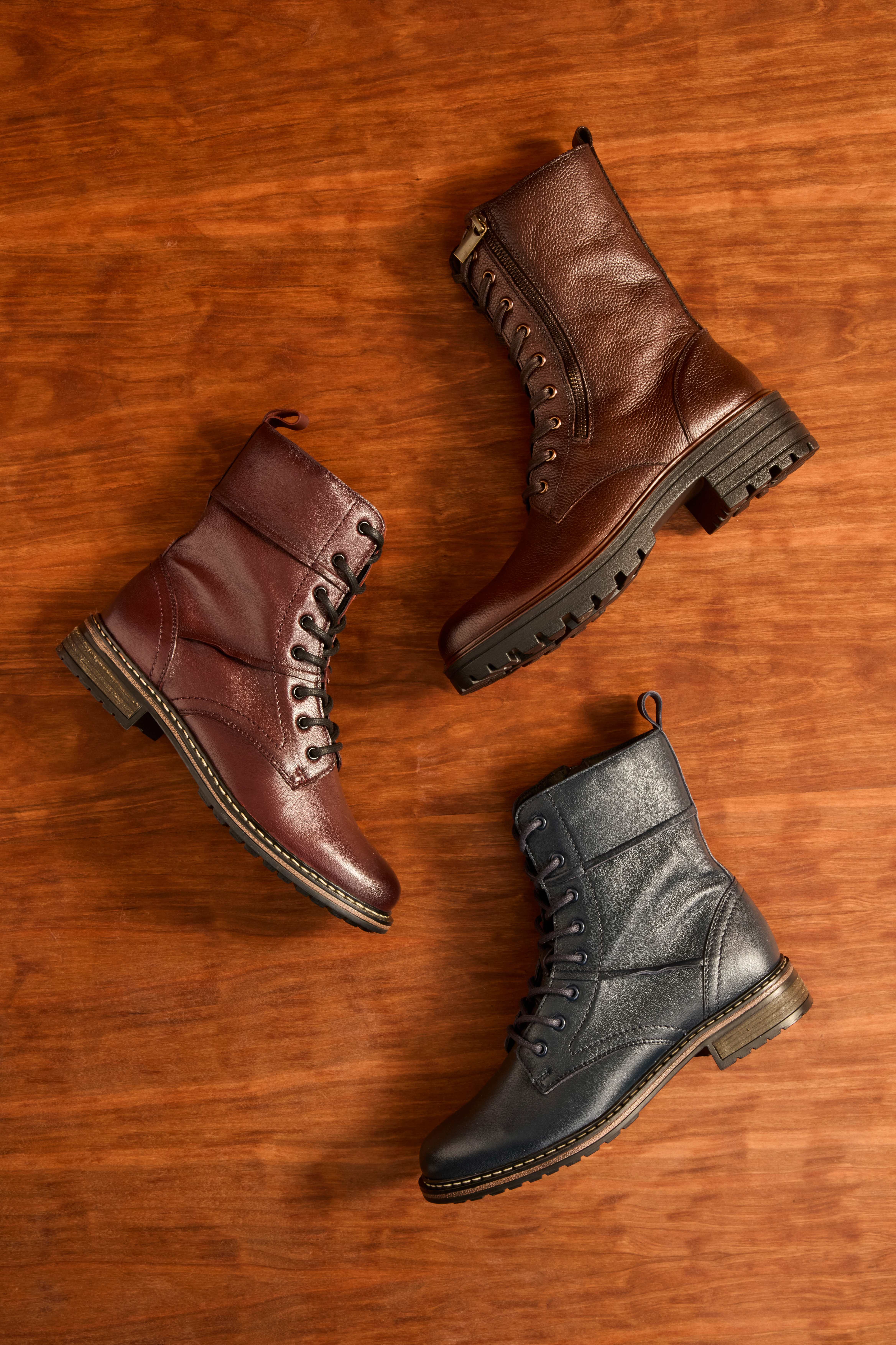 Top-Down-Ansicht dreier Lederstiefel auf Holzfußboden