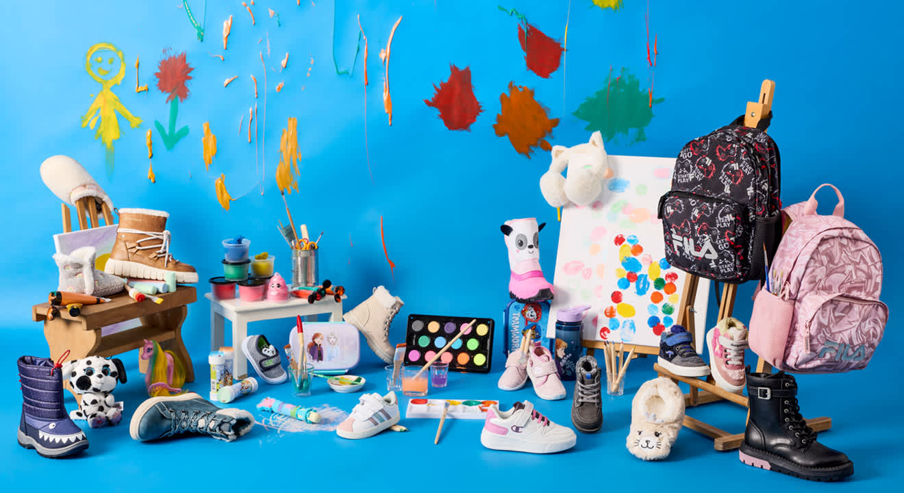 Bunte Kollektion an warmen Kinderschuhen, Bastel- und Spielmaterialien mit einer Staffelei, vor blauem Hintergrund.