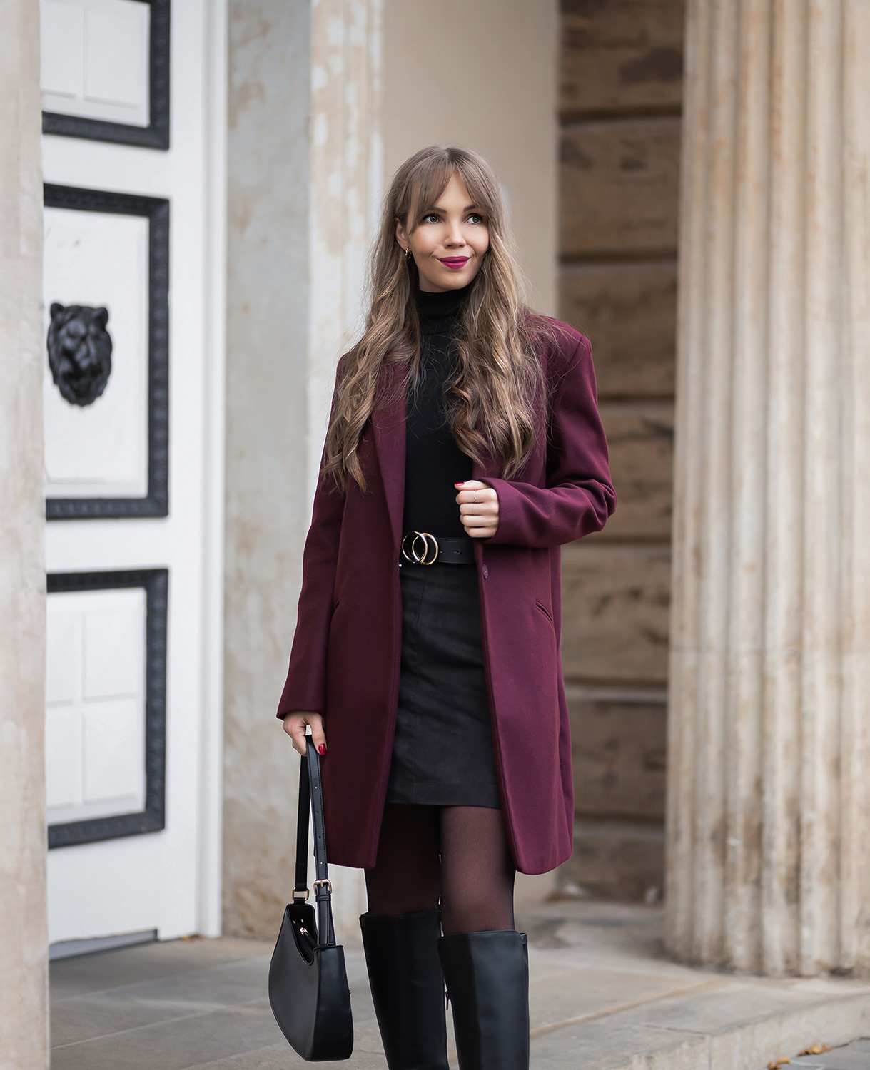 Frau mit elegantem Outfit in Burgunder und Schwarz als zeitlose Mode-Kombination